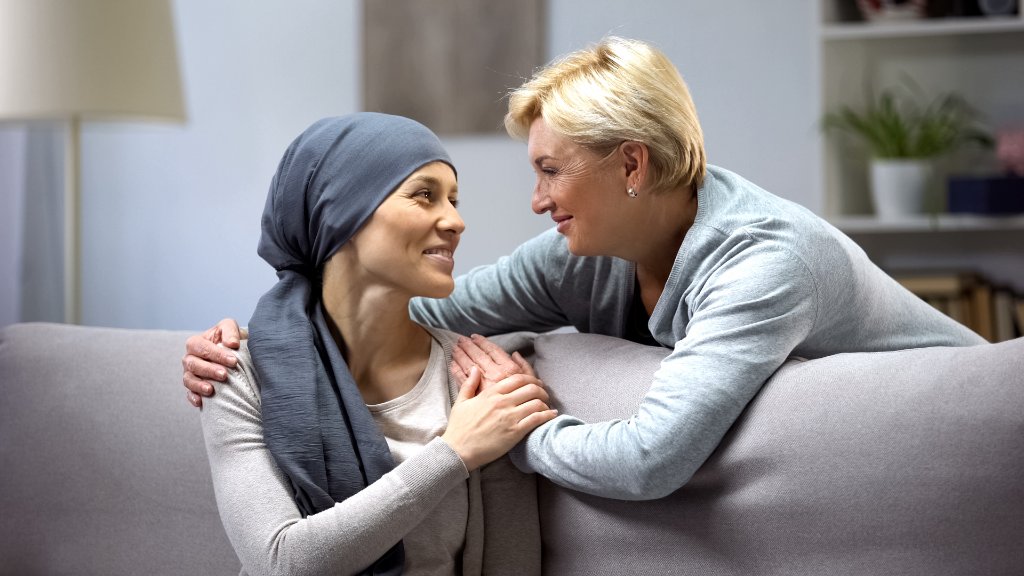 A woman comforting a loved one during medical treatment at home